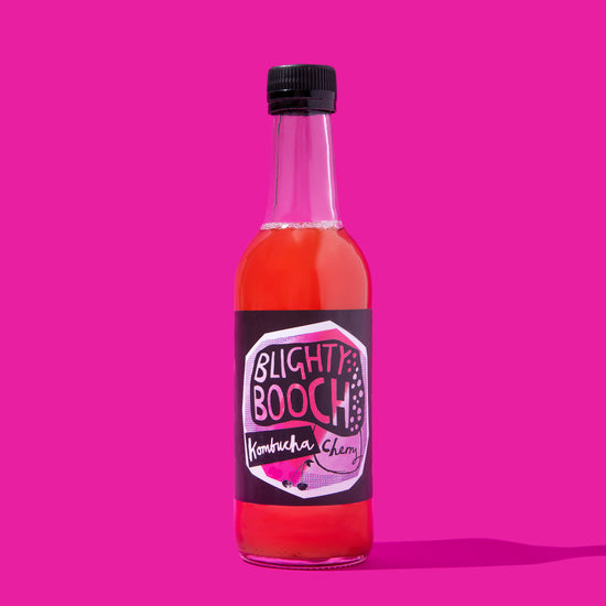 Bottle of Blighty Booch Cherry Kombucha on a Magenta background