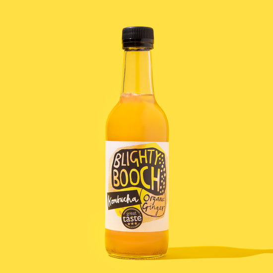 Bottle of Blighty Booch Organic Ginger Kombucha on a Yellow background